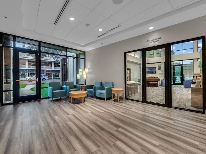 Lobby seating area with glass doors and a ceiling with acoustical panels.